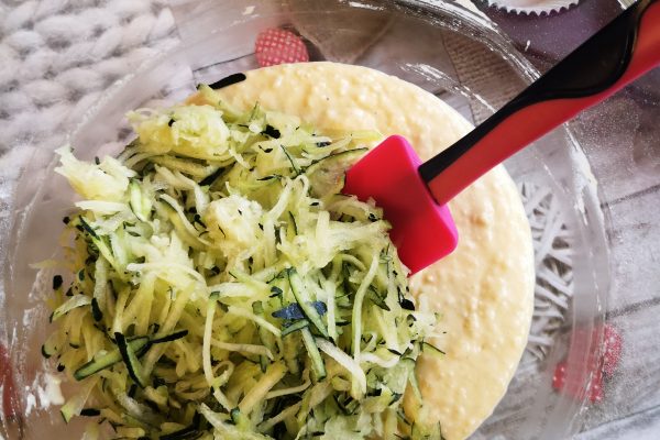 Grattugiate la zucchina usando una grattugia a fori grossi e amalgamatela al composto, senza lavorarlo troppo.