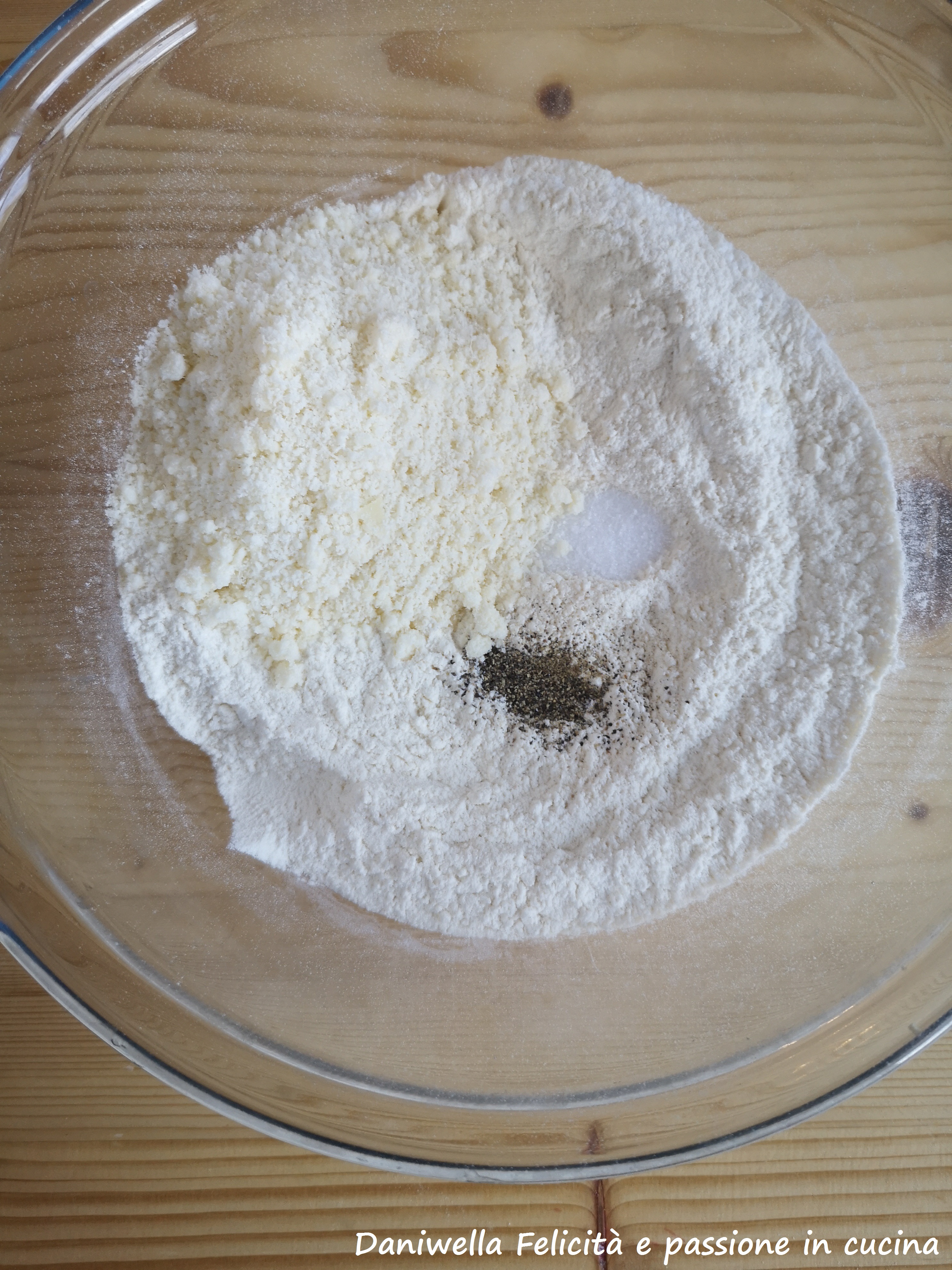 In una ciotola mettete la farina setacciata insieme al lievito, il Parmigiano, il sale e tutte le spezie. Mescolate.